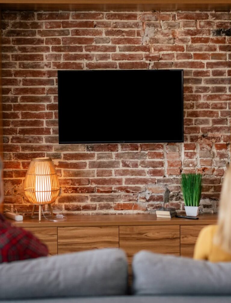 tapeta w salonie na jednej ścianie z telewizorem z cegłą